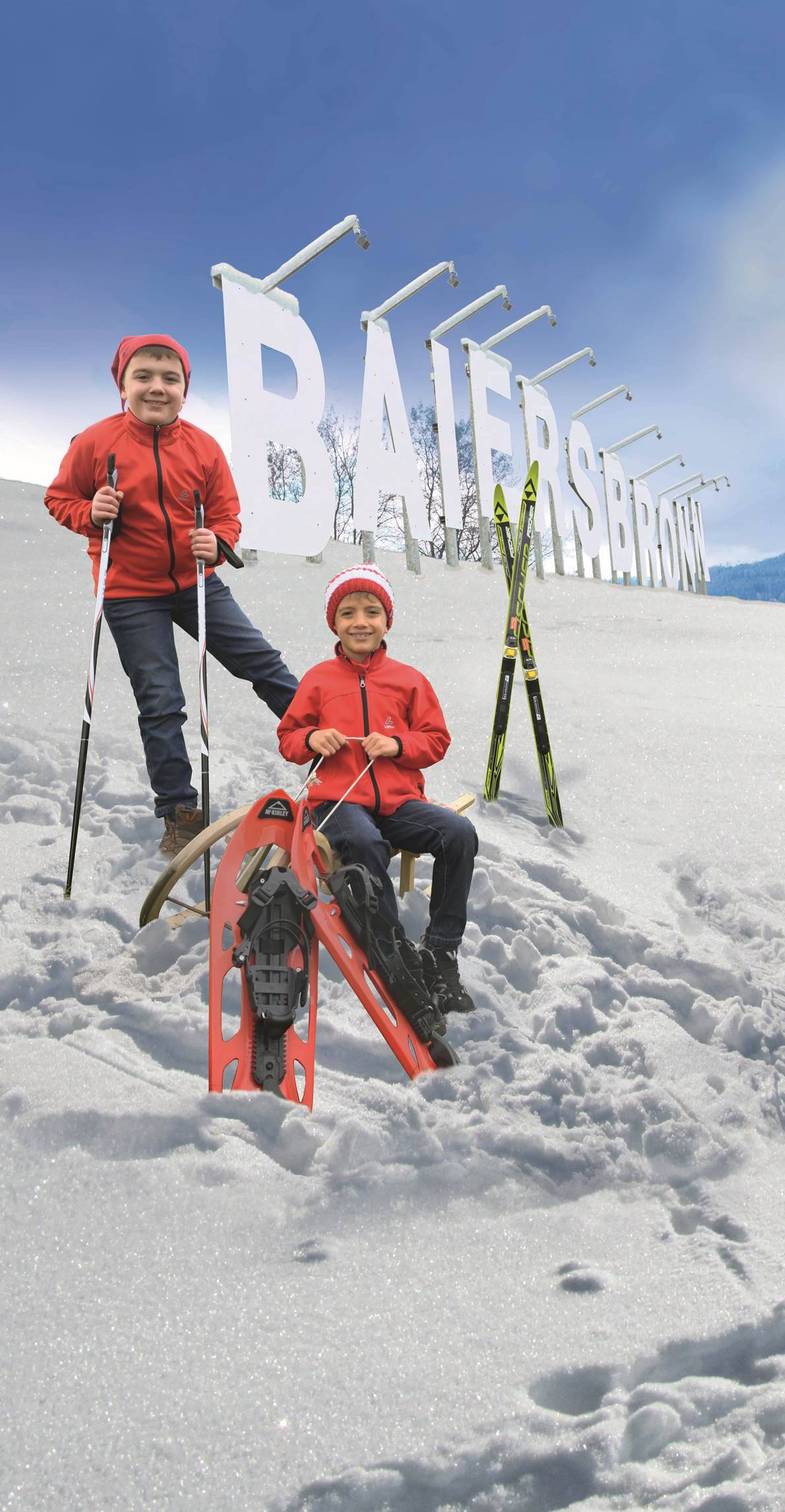 Kinder mit Winterausrüstung sitzen vor großem Baiersbronn Schriftzug